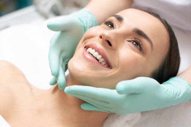 istockphoto-1146321090-612x612 Close up photo of the face of smiling woman and hands in green rubber gloves touching it gently