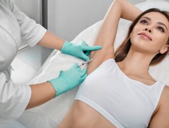 Underarm hyperhidrosis treatment. Armpit injections to prevent excessive sweating for female patient with beautician at cosmetology