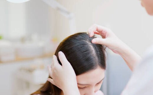 istockphoto-1488632619-612x612 close up asian professional female dermatologist examines head skin of woman with her hands while they discussing in clinic