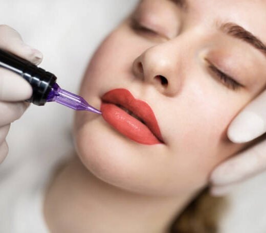 istockphoto-1778642004-612x612 Lip Blushing. Cosmetologist applying permanent make up on lips of beautiful woman, closeup of attractive young female getting pmu treatment in beauty studio, artist using tattoo pen machine